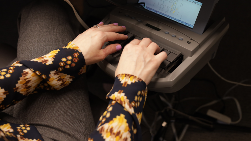 court reporter hands on a stenograph